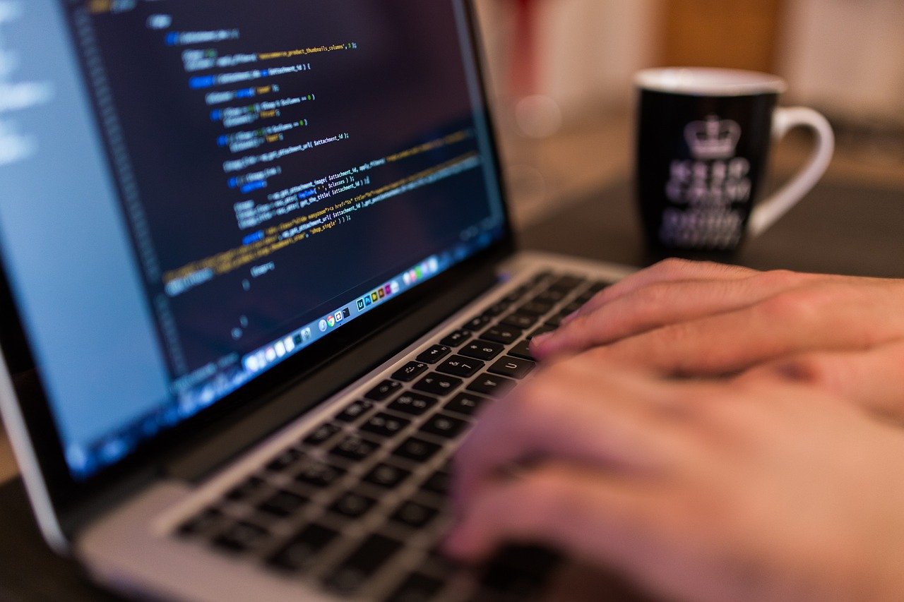 Person typing a coding language on laptop